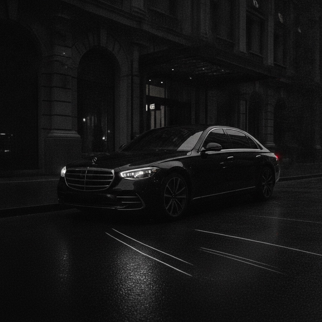 Black Mercedes-Benz S-Class outside a hotel at night